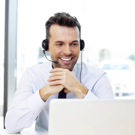 Man with headset in front of laptop