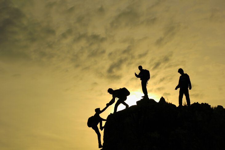 Trabajo en equipo para subir a la cima de la montaña